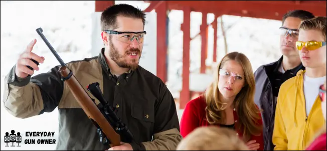 man teaching group about gun safety