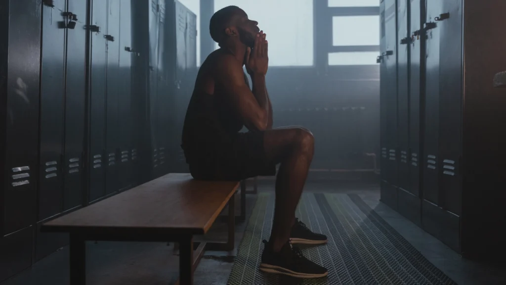 man sitting on locker room bench