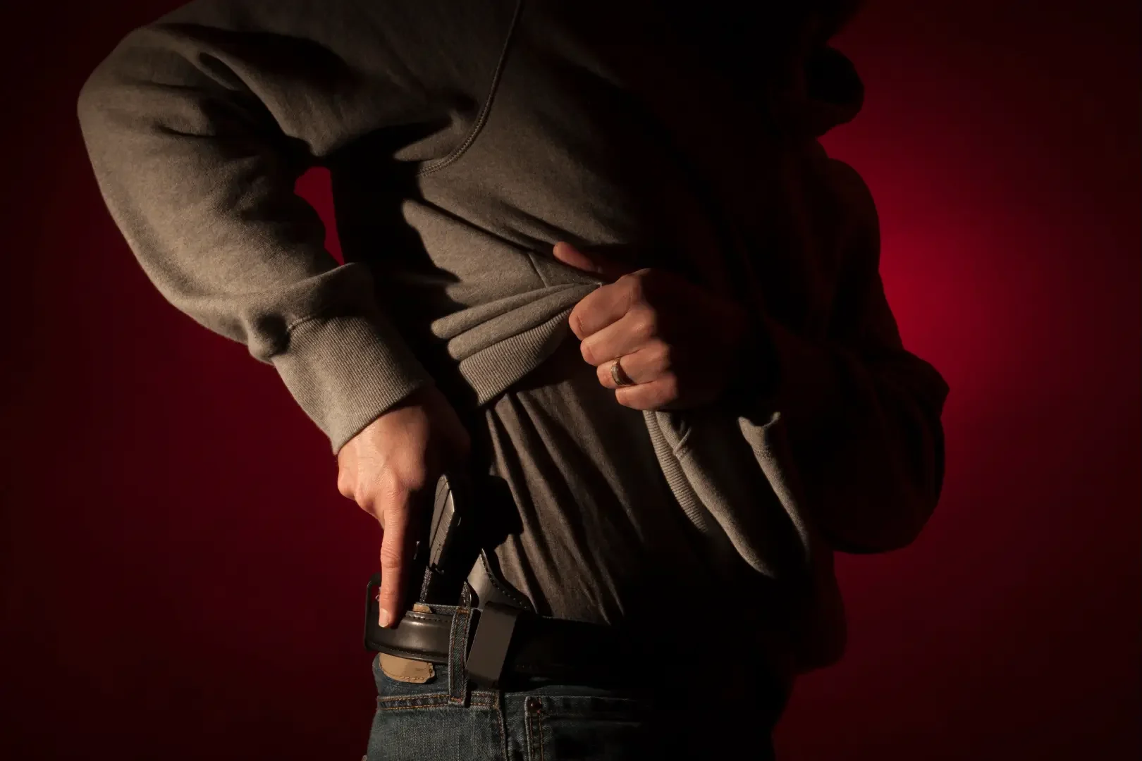 man reaching for concealed gun